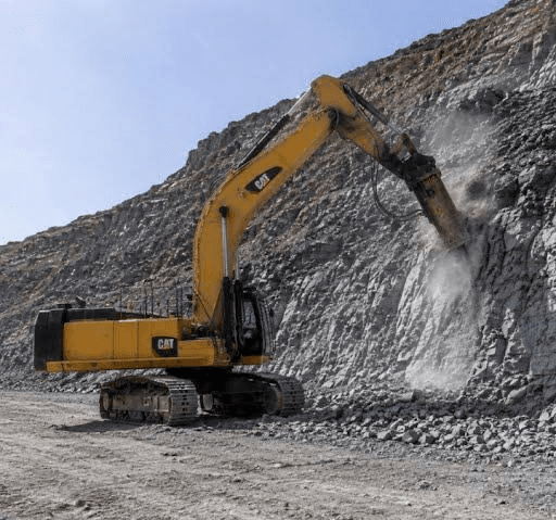CAT excavator with hydraulic breaker working on rock